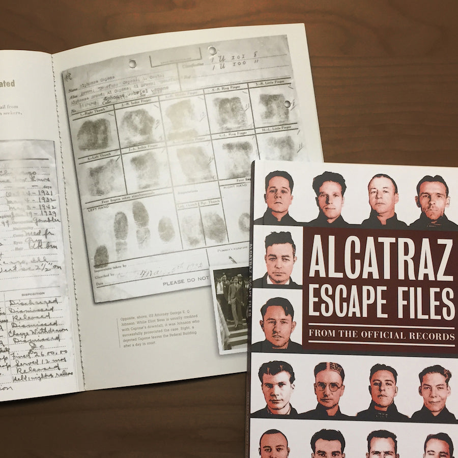 The book Alcatraz Escape Files open on a dark wooden tabletop