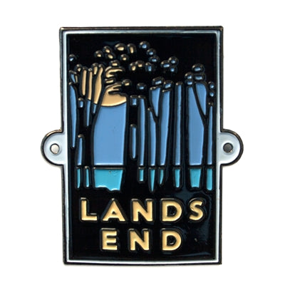 A metal hiking medallion with an embossed design featuring trees and the text 'Lands End', attached to a metal ring and nails.