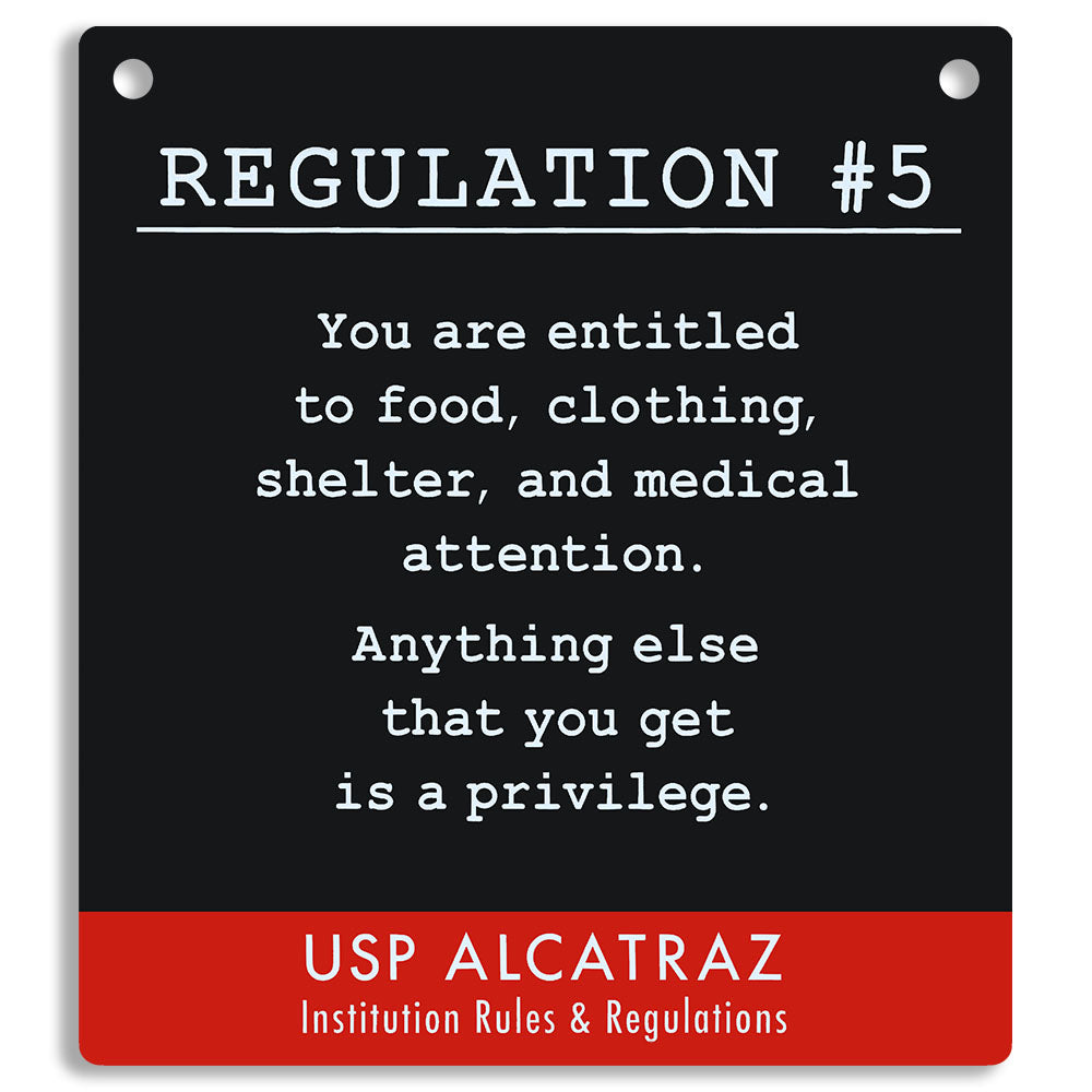 Sign with text from USP Alcatraz about rules and regulations, on a black and red background. "You are entitled to food, clothing, shelter, and medical attention. Anything else that you get is a privilege."