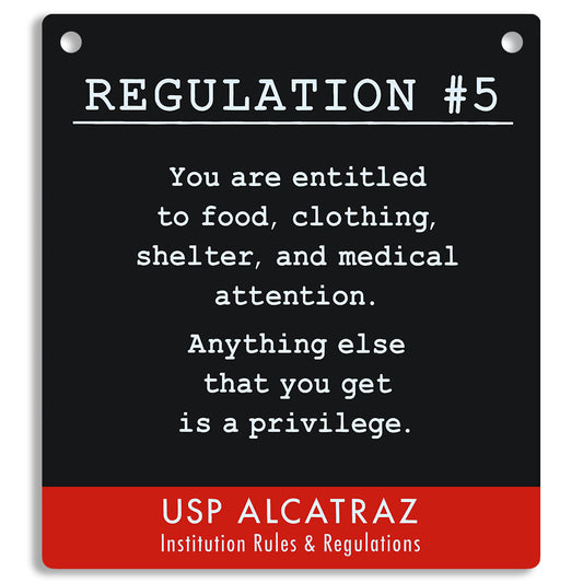 Sign with text from USP Alcatraz about rules and regulations, on a black and red background. "You are entitled to food, clothing, shelter, and medical attention. Anything else that you get is a privilege."