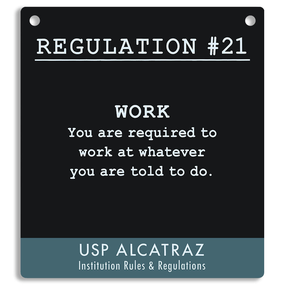 Black sign with white text and blue border, featuring a regulation from USP Alcatraz. "You are required to work at whatever you are told to do."