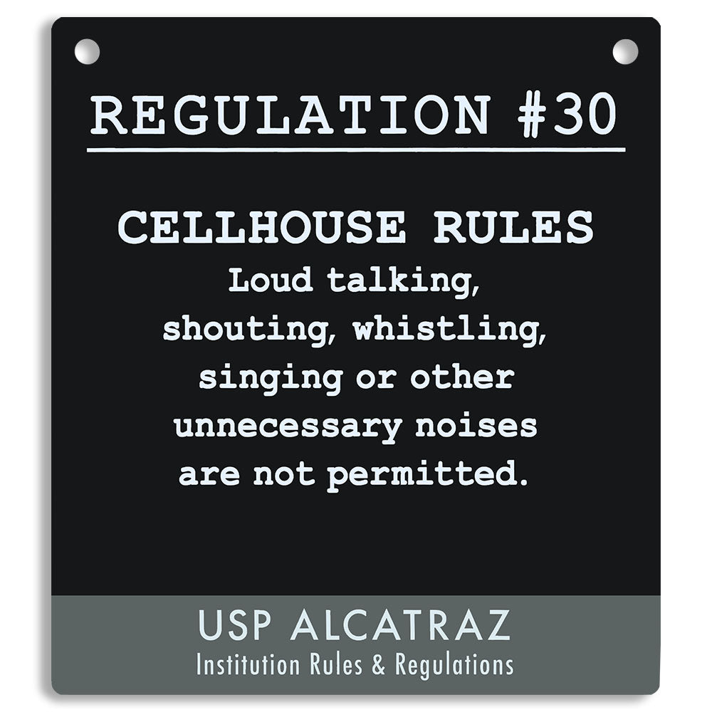 Black sign with white text listing cellhouse rules at USP Alcatraz, from Rules and Regulations. "Loud talking, shouting, whistling, singing or other unnecessary noises are not permitted."