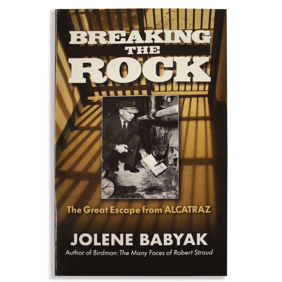 Book cover of 'Breaking the Rock' featuring a man breaking through a rock with the subtitle 'The Great Escape from Alcatraz' by Jolene Babyak.